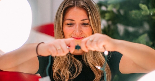 woman plugging in holiday lights